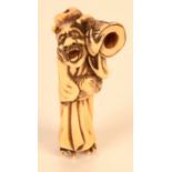 An ivory netsuke carved as an Oni carrying a claw, height 6cm.