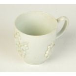 A Bow porcelain coffee cup, 18th century, with prunus moulded decoration, height 5.5cm, diameter 5.