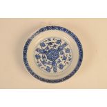 A Chinese blue and white saucer dish, decorated with swastikas, tendrils and a central rosette,