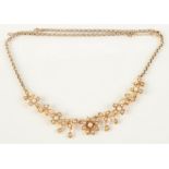 An Edwardian high purity gold pearl set necklace with a row of flowerheads,