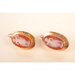 A pair of hardstone cameo set gold earrings.