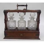 A Victorian three section oak tantalus, with silver plated handle and mounts,