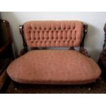 A Victorian walnut sofa, with a button upholstered padded back flanked by fluted and turned columns,