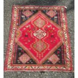 A Shiraz rug, south west Persia, the madder field with three central linked medallions,
