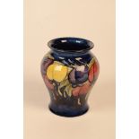 A William Moorcroft Plum Wisteria pattern vase, blue ground with purple, red,