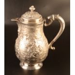 A silver coloured metal jug and cover the pair shaped body richly repousse decorated with wild boar