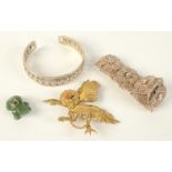 A carved jade frog, a filigree bracelet, an eastern silver bracelet and one other piece.