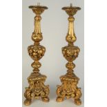 A pair of gilt moulded candlesticks with tripod bases in 18th century European style.