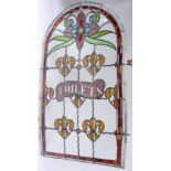 A Victorian stained glass and leaded arched window, inscribed 'Toilets', height 104cm, width 61cm.