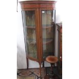 An Edwardian mahogany bow front display cabinet, with a single glazed door on splay legs, 155.