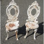 A pair of Victorian white painted cast iron garden chairs, height 98cm.