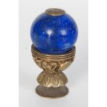A Chinese gilt metal and blue glass hat finial, circa 1900, decorated with shou symbols, height 6cm.
