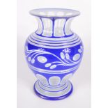 A bohemian blue and white enamelled glass vase, of baluster form, decorated with stylised leaves,
