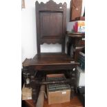 An oak side chair, 17th century, with a solid panelled back above a solid seat,