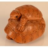 A wooden netsuke carved as two turtles, height 3cm, length 4.5cm.