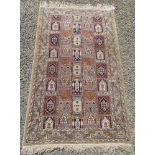 A Pakistan rug, the polychrome compartment field filled with mihrabs and medallions,