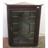 A mahogany corner cupboard, 19th century, the astragal glazed door enclosing three shelves,