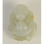 A Chinese mutton fat jade pebble carved as a squatting monkey holding a large peach,