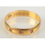 A 22ct gold late Victorian band gypsy set with three rubies, size Q, 2.4g.