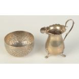A small Indian silver repoussé decorated bowl and a Georgian style bellied silver cream jug on