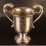 A Georgian style trophy cup the twin handles each with lion mask finials, 18.8oz.