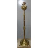 A Victorian brass standard extending oil lamp, with a white glass shade, extended height 188cm.