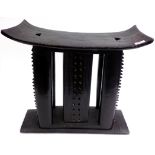 An African Ashanti black painted, carved wood stool, height 54cm, width 58.5cm, depth 20.5cm.