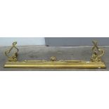 A brass fender, 19th century, with stylised dragons beneath a pair of reeded handles,