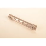 A French 1920s matt white gold baton brooch, each end with bands of diamonds,