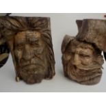 Two tree stumps carved with bearded masks, heights 50cm and 51cm.