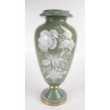 A green glass baluster vase, with white enamel floral decoration, height 41cm.