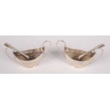 A pair of elliptical half fluted twin handled silver salts with matching spoons by James Dixon &