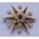 A 9ct gold star brooch set with garnets and pearls, 7.2g.