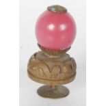A Chinese gilt metal and pink glass hat finial, circa 1900,