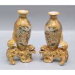 A pair of Japanese Satsuma pottery vases, mounted upon the back of a dog of fo,