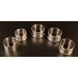 A pair of silver napkin rings and three other silver napkin rings, 3.4oz.