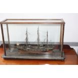 A wooden model of a full rigged ship, 'Stuart John', in a glazed wooden case on bun feet,