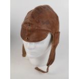 A brown leather flying helmet, label inscribed 'A.W. Gamage Ltd.