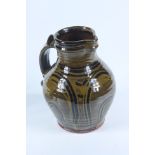 A Doug Fitch slipware jug, the ribbed body with a green and brown glaze, height 23cm.