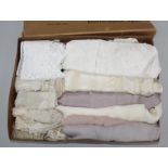 A box of delicate silk scarves, one blush, two pale lilac and two ivory,