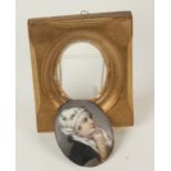An oval porcelain plaque, decorated with a female figure wearing a white head scarf,