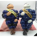 Two blue painted plastic figures of Michelin men.