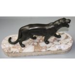 An Art Deco spelter model of a puma, on a marble plinth, height 19cm, width 38cm.