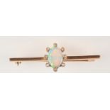 A gold fire brooch with an oval opal surrounded by eight diamonds.