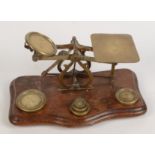 A set of Victorian brass post office scales, with weights, height 12cm, width 25cm.
