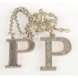 A silver 'P' decanter label and a silver coloured metal 'P' decanter label.