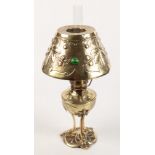 An Arts and Crafts brass oil lamp, the shade set with hardstones amongst foliage,