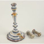 An 18th century faience candlestick and a pair of faience holly chrome knife rests.
