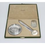 A Christofle cased set comprising a bottle opener, a paper knife and a pin tray.