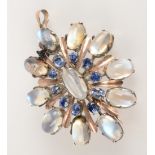 A 1950s silver and gold pendant brooch set with moonstones and sapphires.